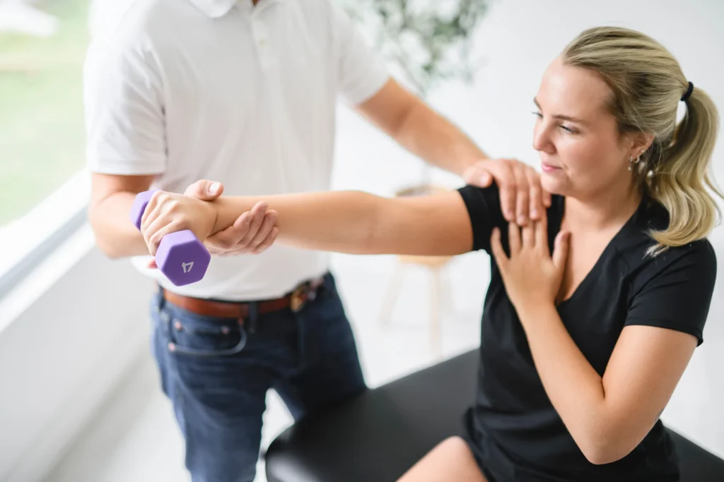 Patientin beim angeleiteten Krafttraining zur Stärkung von Schulter, Gelenken und Muskulatur in der Orthopädie