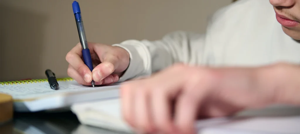 Schüler schreibt während des Lernens in ein Heft