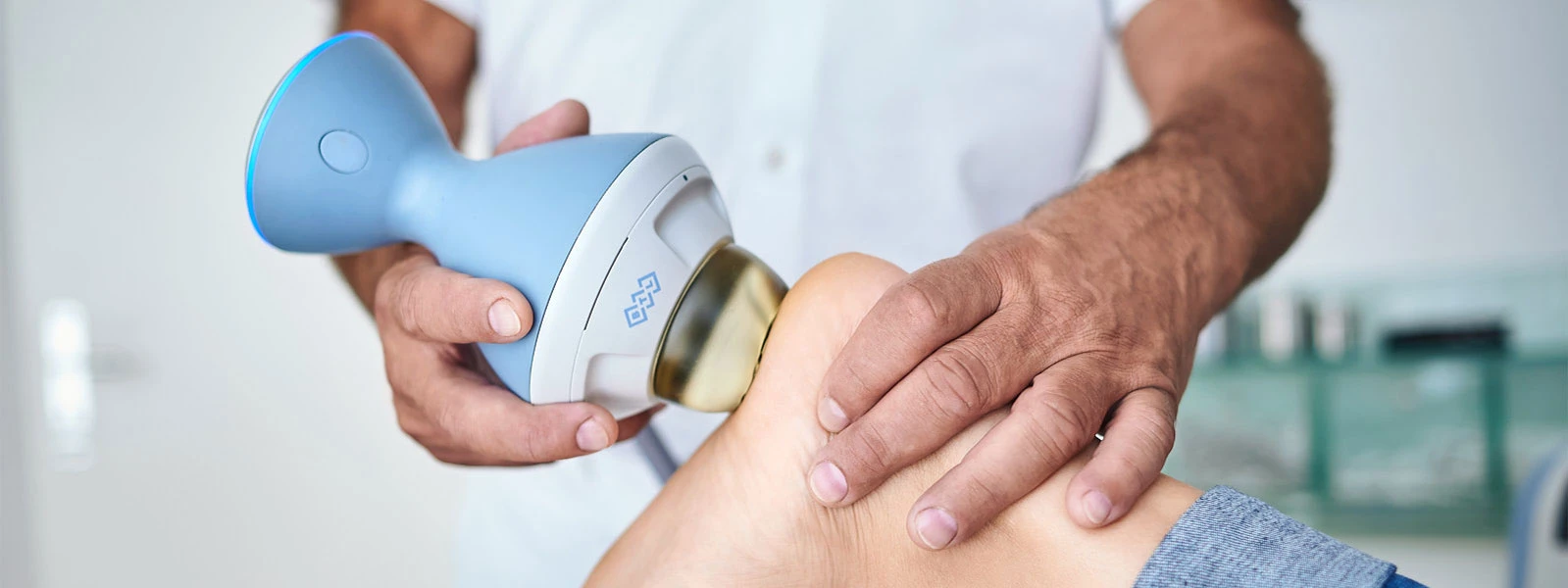 Stoßwellentherapie am Fuß einer Patientin
